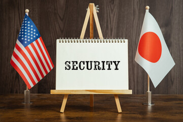 There is a sketchbook between the U.S. and Japan flags, and the letters Security are written on it.