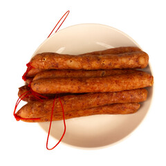 Thai pork sausage on a white plate against a white background
