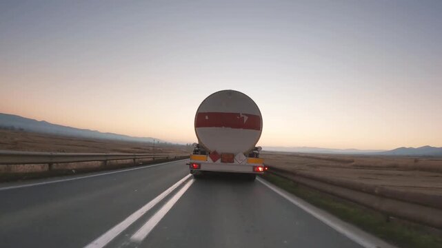 Automotive fuel tankers shipping fuel driving fast at sunrise, sunset