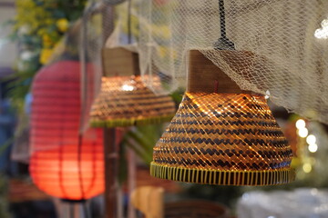 Traditional Indonesian-style pendant lights made of woven bamboo with a warm glow, decorated with fishing nets for a rustic or ethnic-themed event interior