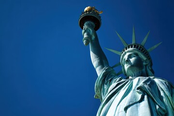 Fototapeta premium close-up of the statue of liberty holding a torch, with a blue sky background