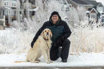 winter portrait of a man with his dog in the snow