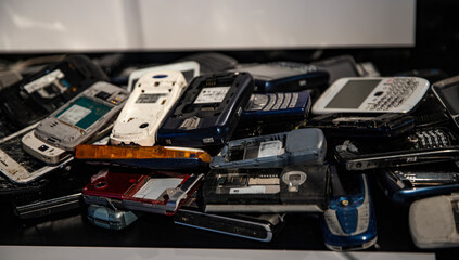 heap of old broken mobile phones for electronic waste recycling
