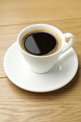 Aromatic coffee in cup on wooden table, closeup