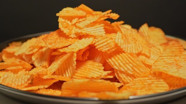 Crispy golden potato chips are falling slow motion. Fast food and junk food. Unhealthy food with high calories, unhealthy fats, salt, and chemical byproducts. Ultra processed snack. High health risks