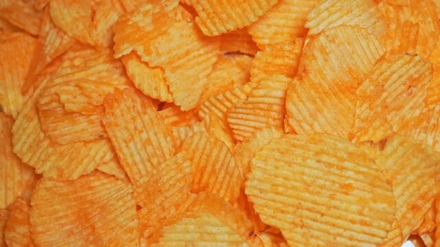Crispy golden potato chips are falling slow motion. Fast food and junk food. Unhealthy food with high calories, unhealthy fats, salt, and chemical byproducts. Ultra processed snack. High health risks