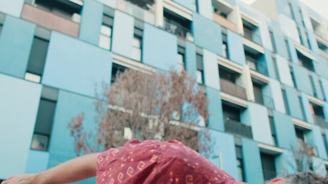 Young Man Dancing in Front of Blue Building