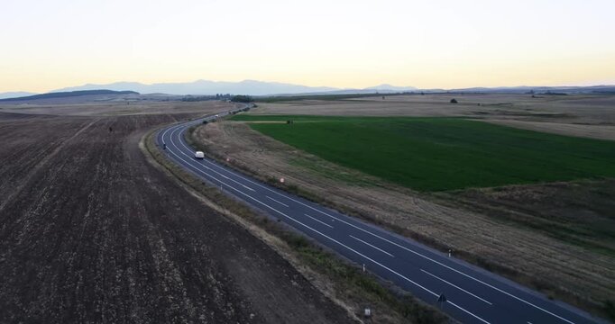 Aerial view of suspicious van make crime transportation of illegal goods on rural road at sunset. Vehicle drive without plate numbers to protect from police identification