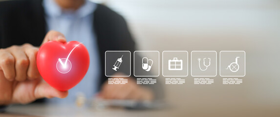 The doctor's hand is choosing the heart with medical health care icons for safety insurance for sick illness wellbeing protection plan or retirement healthy therapy treatment or health checkup