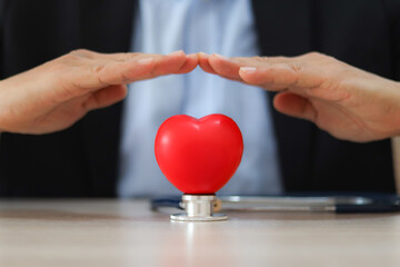 The doctor's hand is choosing the heart for medical health care for safety insurance for sick illness wellbeing protection plan or retirement healthy therapy treatment or health checkup concepts.