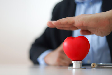 The doctor's hand is choosing the heart for medical health care for safety insurance for sick illness wellbeing protection plan or retirement healthy therapy treatment or health checkup concepts.