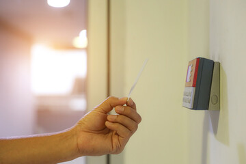Hand scanning proximity ID card on reader access control system to security door unlock with identity or verification identify icons for safety detect fingerprint scan or check attendance.