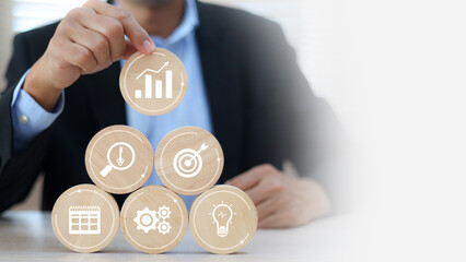 Hand chooses wooden toy stack pyramid with graph and business strategy icon for target goal to growth and financial marketing analysis or human resource management and investment concepts.