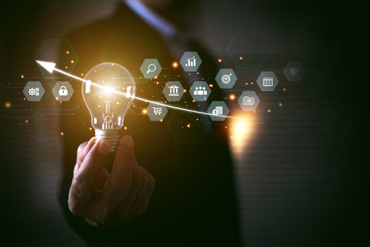 Businessman's hand is choosing light bulb with business creativity icons for plan to goal or creative idea innovation or analyzing marketing data management and target growth or human resources. - Powered by Adobe