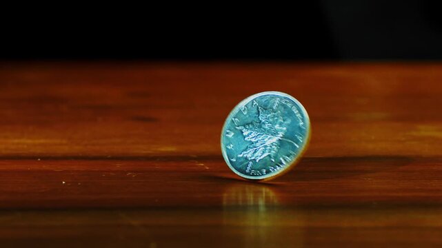 close up of one ounce maple leaf silver coin spins on the table in slow motion