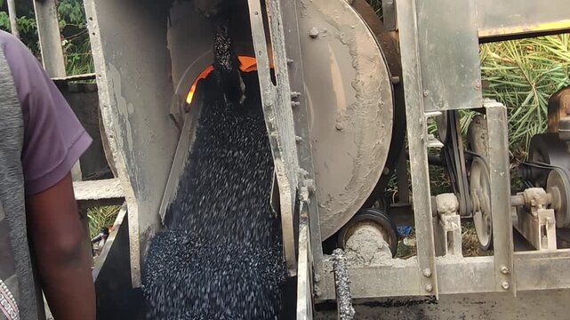 Workers using a machine to mix asphalt, Close up of a Bitumen Mixing Machine OR Asphalt Mixer, it is widely used in India and road construction contexts.