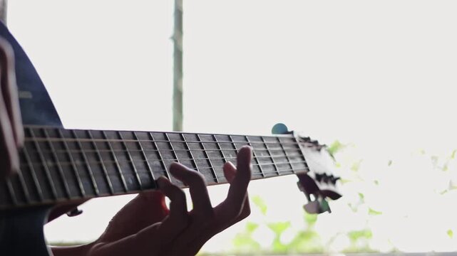 Close up of a musician's hands playing chords on an acoustic wooden guitar, representing passion for music, creativity, and acoustic melodies