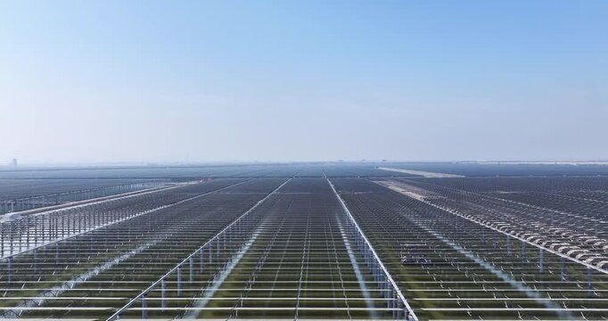 aerial video of a large-scale coastal solar-fishery hybrid project under construction, clean energy meets aquaculture on tidal flats.