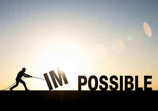 Silhouette of a man pulling away the letters IM from the word impossible to create the word possible against a sunset sky.