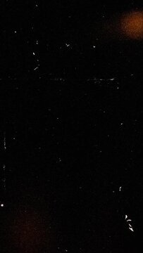 Authentic vintage vertical analog film frame animation with moving sprocket holes and vibrant light leak overlays