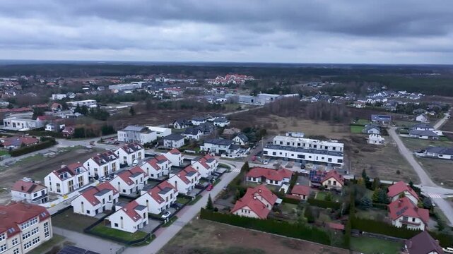 Aerial Osielsko parish city Poland neighborhood slide . Modern city historical Polish architecture. Apartment complex, school, sports fields, parks and individual private residential homes and houses.