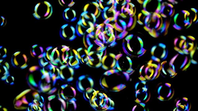 Multicolored iridescent bubbles floating against a black background with a white border at the bottom.