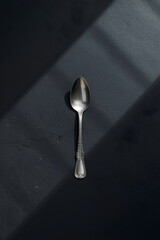 Top Down Flat Lay View of Antique Silver Spoon on Dark Textured Background