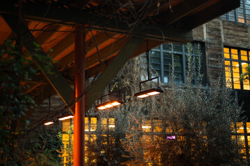 Outdoor cafe equipped with infrared heaters suspended from ceiling to comfortably warm visitors...