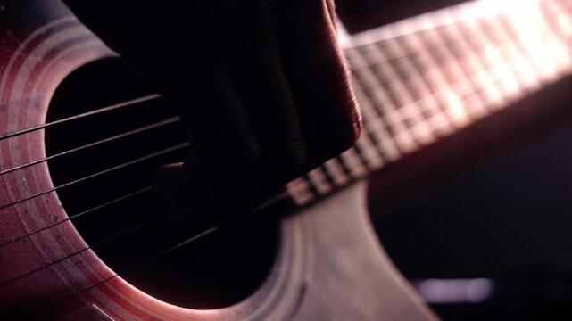 Artistic close up of hands strumming an acoustic wooden guitar under warm cinematic lighting, representing passion for music and soulful creativity