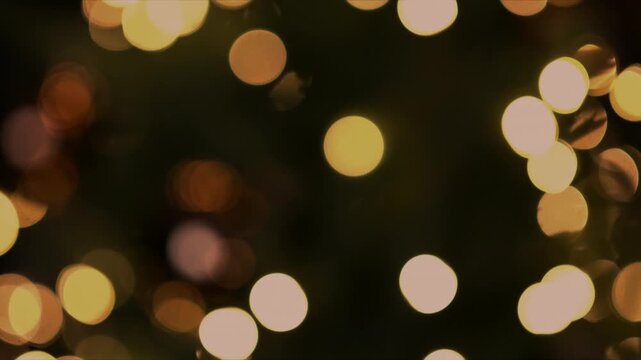 Blurred Luxurious Christmas tree with glass ornaments and warm fairy bokeh lights  