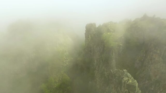 Footage of misty landscape view of the rugged cliffs and deep valleys of the Kara-Syrt Ridge in Dagestan, part of the North Caucasus Mountains in Russia. The scene captures the natural beauty and dram