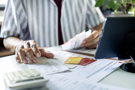 asian man checking receipts and financial bills calculate expenses from credit card debt checking bank statement before paying debt