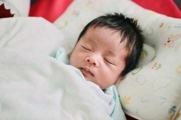 Closeup of a newborn baby sleeping in bed