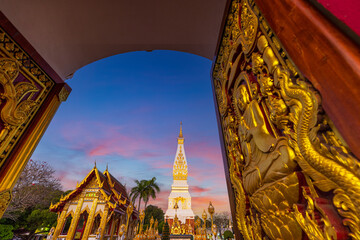 Phra That Phanom Pagoda view through ornate temple gates at sunset, Nakhon Phanom, Thailand,A...