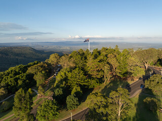 Scenic elevated views of the Australia flag on display at the Picnic Point public park area in Toowoomba with Table Top Mountain and the Bushland Reserve in the background, Queensland, Australia