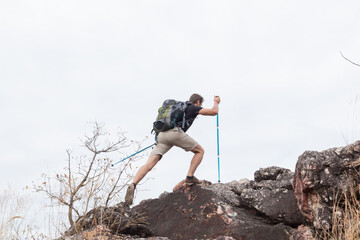 Caucasian healthy male hiking walking climb up the mountain in holiday autumn alone, backpack...