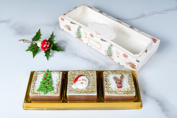 Brazilian honey cakes lined up and decorated with marzipan in a Christmas theme.