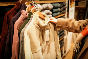 Person Shopping for Winter Sweaters in Store © zhouyilu