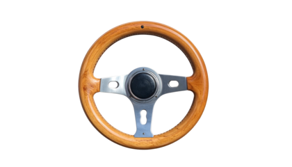 A close-up shot of a classic-style wooden steering wheel with a polished metallic center against a stark black background