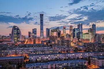 Night view of Beijing CBD skyline with modern skyscrapers and illuminated buildings during blue hour, showing urban development and city life. © VisualCoordinates