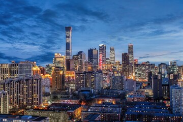 Blue hour cityscape of Beijing Central Business District featuring illuminated modern skyscrapers and dense urban architecture in China.