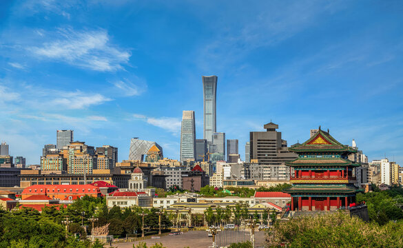 City skyline of Beijing featuring historic Zhengyangmen Gate and modern CITIC Tower under clear blue sky.