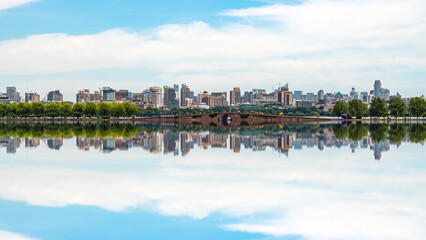 Fototapeta premium Urban Skyline Reflected in Calm Lake Water