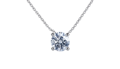 Close-up of a delicate, solitary pendant necklace featuring a sparkling, brilliant-cut gemstone set in a four-prong setting, suspended from a fine silver chain