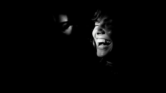 Black and white video showing partial faces of a laughing woman and man in shadow, mocking and cruel. 
Social commentary, bullying awareness, judgment themes, media projects, editorial storytelling.