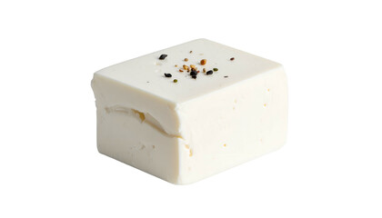 A close-up shot of a white cube-shaped food item, possibly dairy, with peppercorns on top against a black background