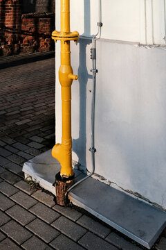 Gas pipe installed next to a lightning protection conductor on a building wall. Risky and unsafe infrastructure solution highlighting safety violations, engineering mistakes