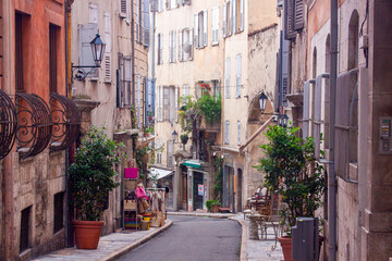 Fototapeta premium Narrow Mediterranean alley lined with stone buildings, small shops, and traditional architecture, capturing authentic daily life in a historic European town.