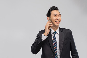 Asian executive on phone smiling confidently, engaged in business call mobile communication scene with striped tie, attentive