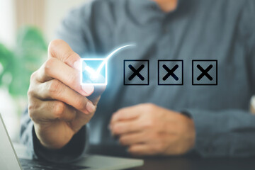 Hand chooses check mark on cross symbol for customer survey service and feedback.